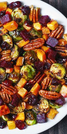 a white plate topped with roasted vegetables and nuts