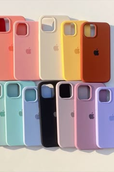 an array of iphone cases lined up on a white surface, all in different colors