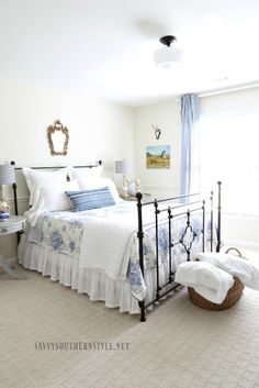 a bed room with a neatly made bed and a basket on the floor next to it