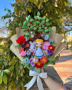 a bouquet made out of crochet and felt is sitting in front of a tree