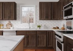 a kitchen with marble counter tops and wooden cabinets, along with white subway tile backsplash