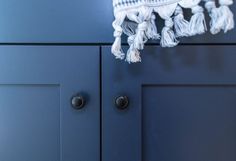 a close up of a blue cabinet with tassels on the door knobs