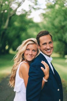 a man in a suit and tie hugging a beautiful blonde haired woman with her arms around him