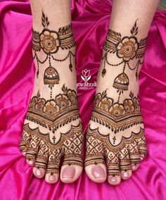 the feet are decorated with henna designs on pink silks, and there is no image here to provide a caption for