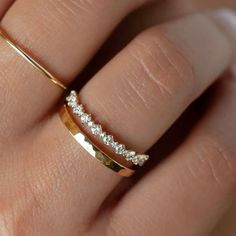 a woman's hand with a gold ring and diamond band