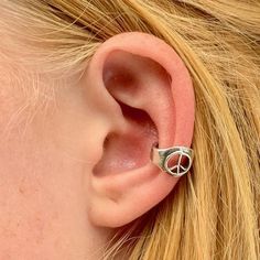 This tiny Peace-Sign Ear Cuff carries a powerful message. The Symbol is carefully cut into the ear cuff band.  It is cast in sterling silver, is 3/8" in diameter and and can be worn on either the left or the right ear. Take a trip back into the 60's wearing this Peace Sign Ear Cuff. May Peace Prevail. This item usually ships the same or next business day.All Marty Magic Jewelry is packaged in a beautiful box, embossed with the gold foil Marty Magic dragon logo. Perfect for any occasion!Designed Opalite Jewelry, Ear Cuff Silver, Magic Jewelry, Peace Earrings, Dragon Logo, Magic Dragon, Octopus Necklace, Fish Jewelry, Silver Ear Cuff