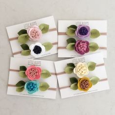 four small flower brooches with leaves on them