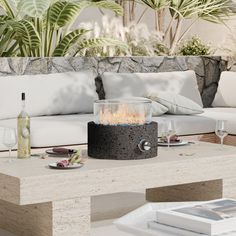 a living room with white couches and a fire pit on the coffee table in front of it