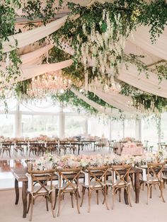 an instagram photo of a wedding venue with flowers and greenery hanging from the ceiling