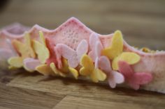 a pink and yellow headband sitting on top of a wooden table