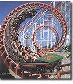 an amusement park ride with people riding on the roller coaster in front of them,