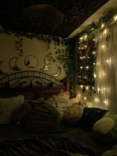 a bedroom with lights strung from the ceiling and bed in front of a wall covered in ivy