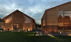 two large wooden buildings sitting on top of a lush green field