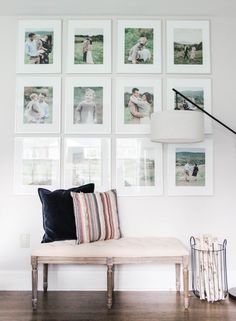 a living room with pictures hanging on the wall and a bench in front of it