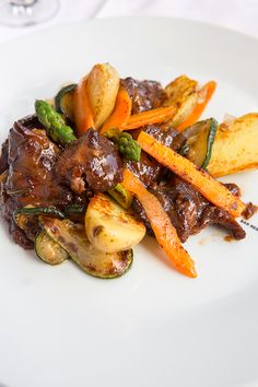 a white plate topped with meat and veggies