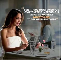 a woman sitting at a table in front of a laptop computer with a quote on it