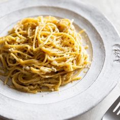 a white plate topped with pasta on top of a table