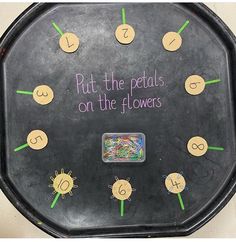 a black clock with writing on it that says put the pedals on the flowers