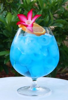 a blue drink with orange and pink flower in it