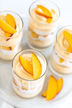 four glasses filled with dessert on top of a table