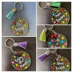 four different key chains with flowers and tassels on them, one has the words be yourself