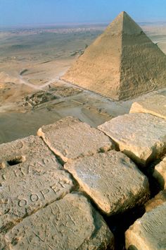 the pyramids are in the distance with writing on stone blocks next to each other