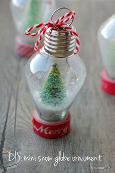 an ornament with a small christmas tree in it on top of a wooden table