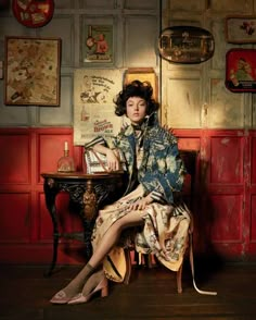 a woman sitting on top of a chair next to a table