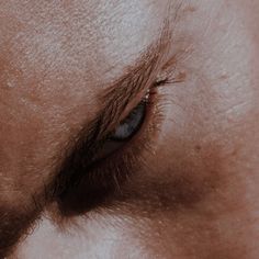 an extreme close up shot of the eye of a man with blue eyeshadow