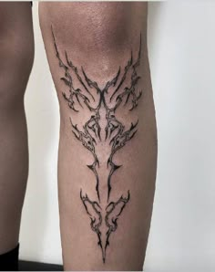 a tattoo on the leg of a man with an intricate design in black and grey