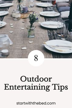 an outdoor dining table with white plates and silverware on it is featured in the article 8 outdoor entertaining tips