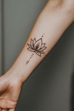 a woman's arm with a lotus tattoo on it