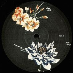 a black disk with white and orange flowers on it