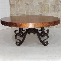 a wooden table sitting on top of a white floor next to a brick wall and door