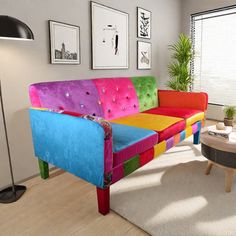 a brightly colored couch sitting in a living room next to a table with a potted plant on it