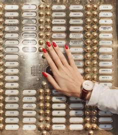 a woman's hand on top of a machine with gold balls around her wrist