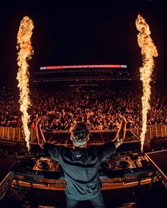 a man standing in front of a dj set on fire