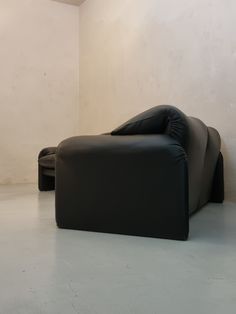 a black leather couch sitting on top of a white floor