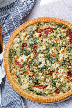 a pizza sitting on top of a pan covered in cheese and spinach toppings