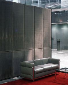 a couch sitting in front of a wall with metal panels on it's sides