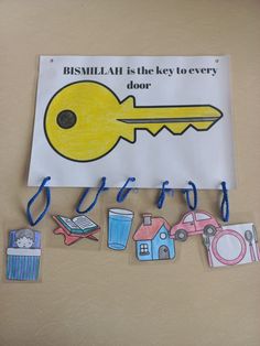 a bulletin board with some pictures on it and a key to the door hanging in front of it