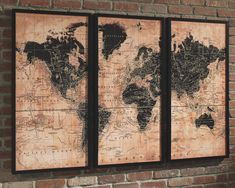 three framed maps on a brick wall