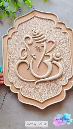 an intricately carved ganeshi on a cookie sheet with flowers in the background