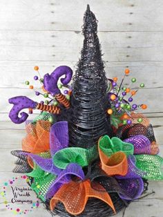 a halloween wreath made out of wire and mesh with purple, orange and green decorations