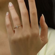 a woman's hand with a diamond ring on it