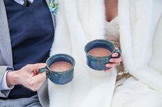 two people are holding mugs in their hands