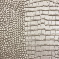 the texture of an alligator skin is shown in white and beige colors, as well as black