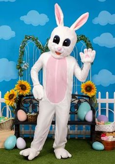 a man dressed as a bunny standing in front of an easter display with sunflowers