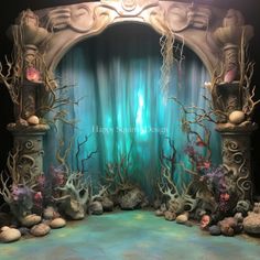 an underwater themed stage set up for a show or party with blue curtains and corals