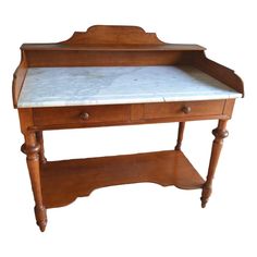 an old wooden desk with marble top and drawer on one side, against a white background